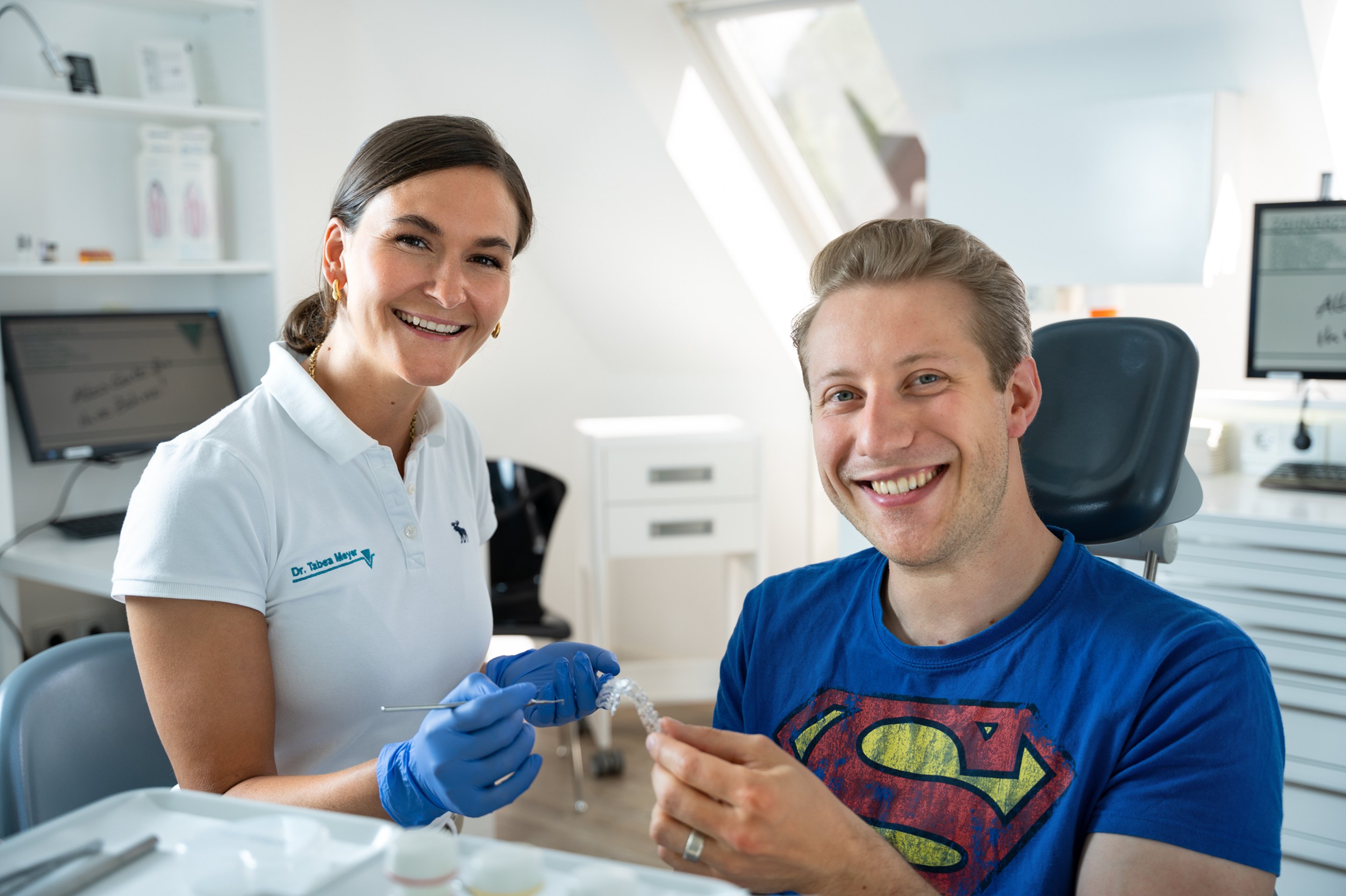 Zahnärztin und Patient lächeln in der Praxis